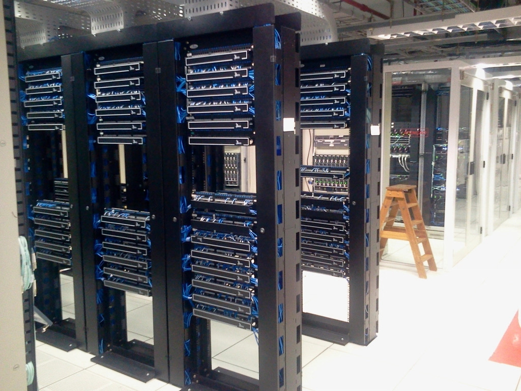 Rows of server racks lit by indicator lights in a data center