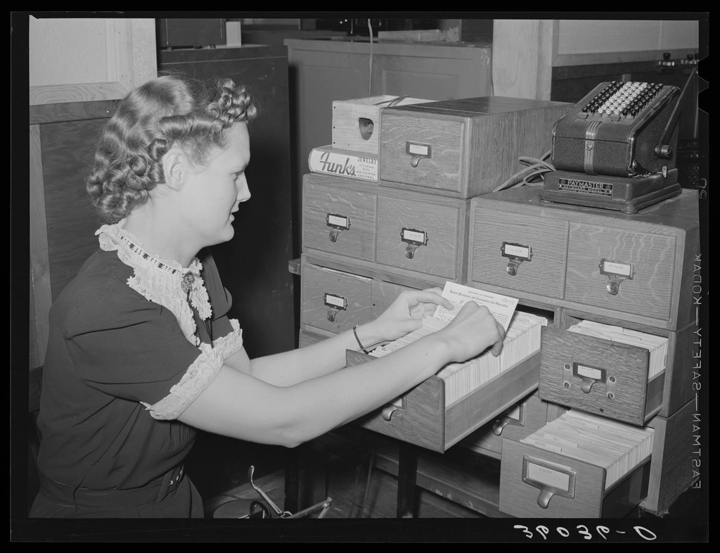 Wooden filing box holding rows of handwritten index cards