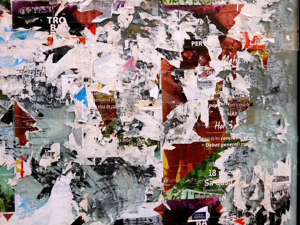 Overlapping torn paper fragments forming a textured collage surface