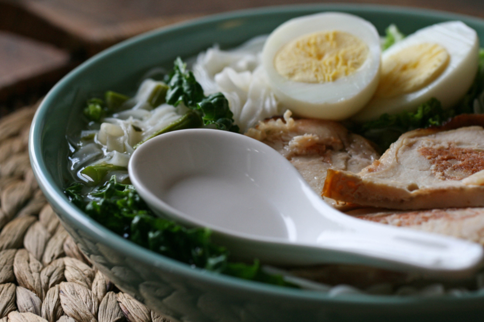 Overhead view of a ramen bowl with noodles, egg and spring onion