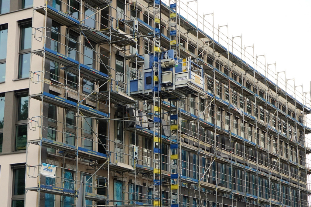 Metal scaffolding erected across the facade of a building under construction